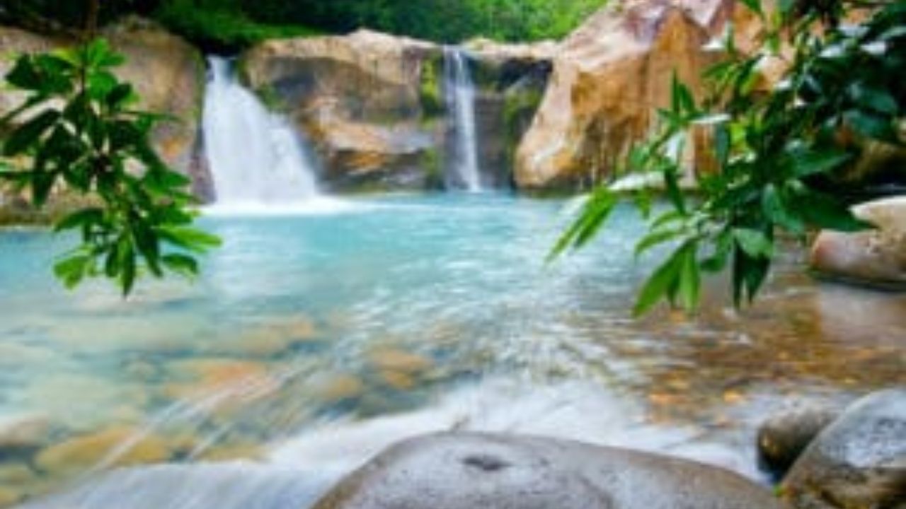  Waterfall cascading into turquoise pool at Rincón de la Vieja. 