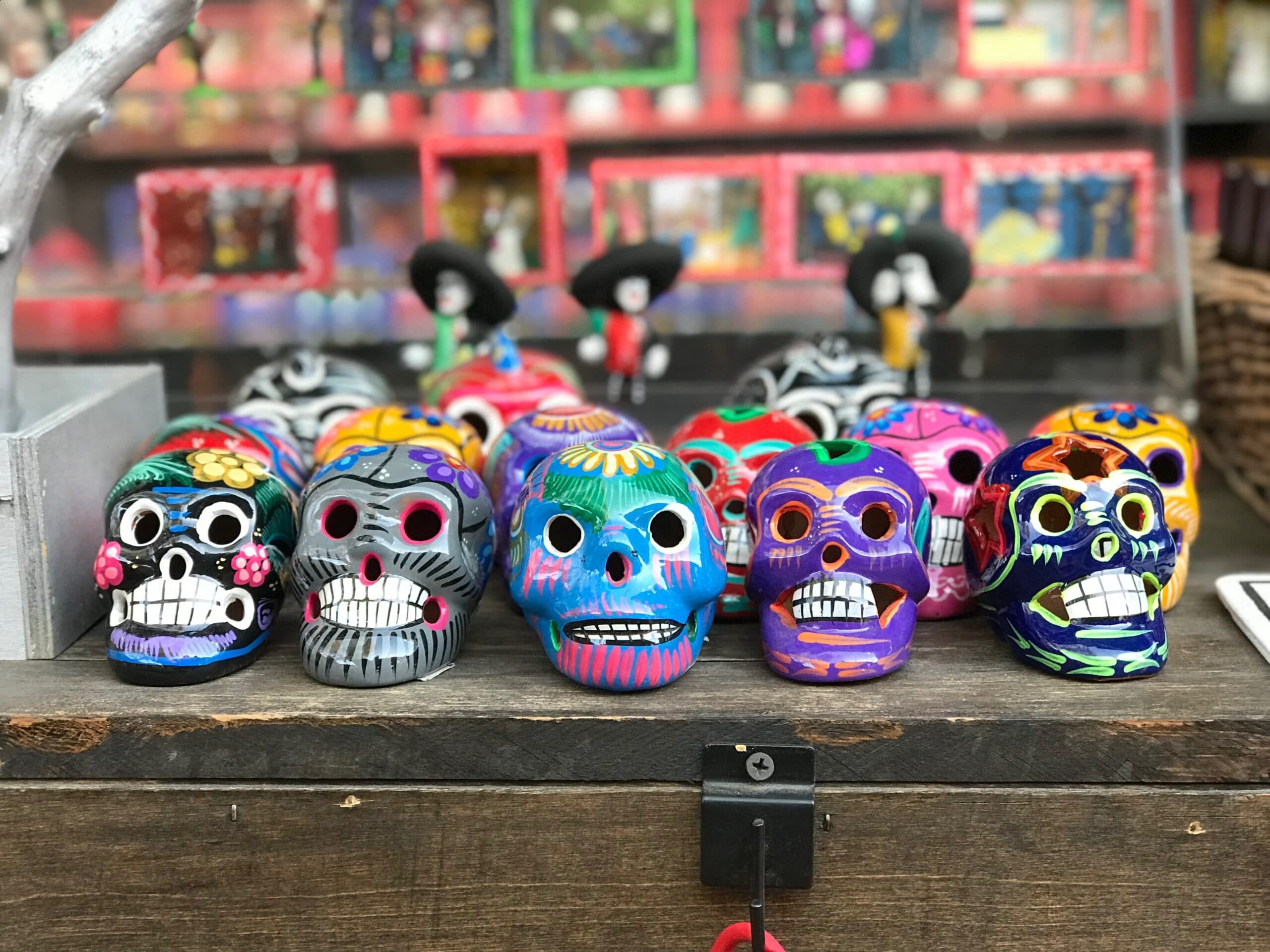  Colorful Día de los Muertos skulls and skeleton figures on display. 